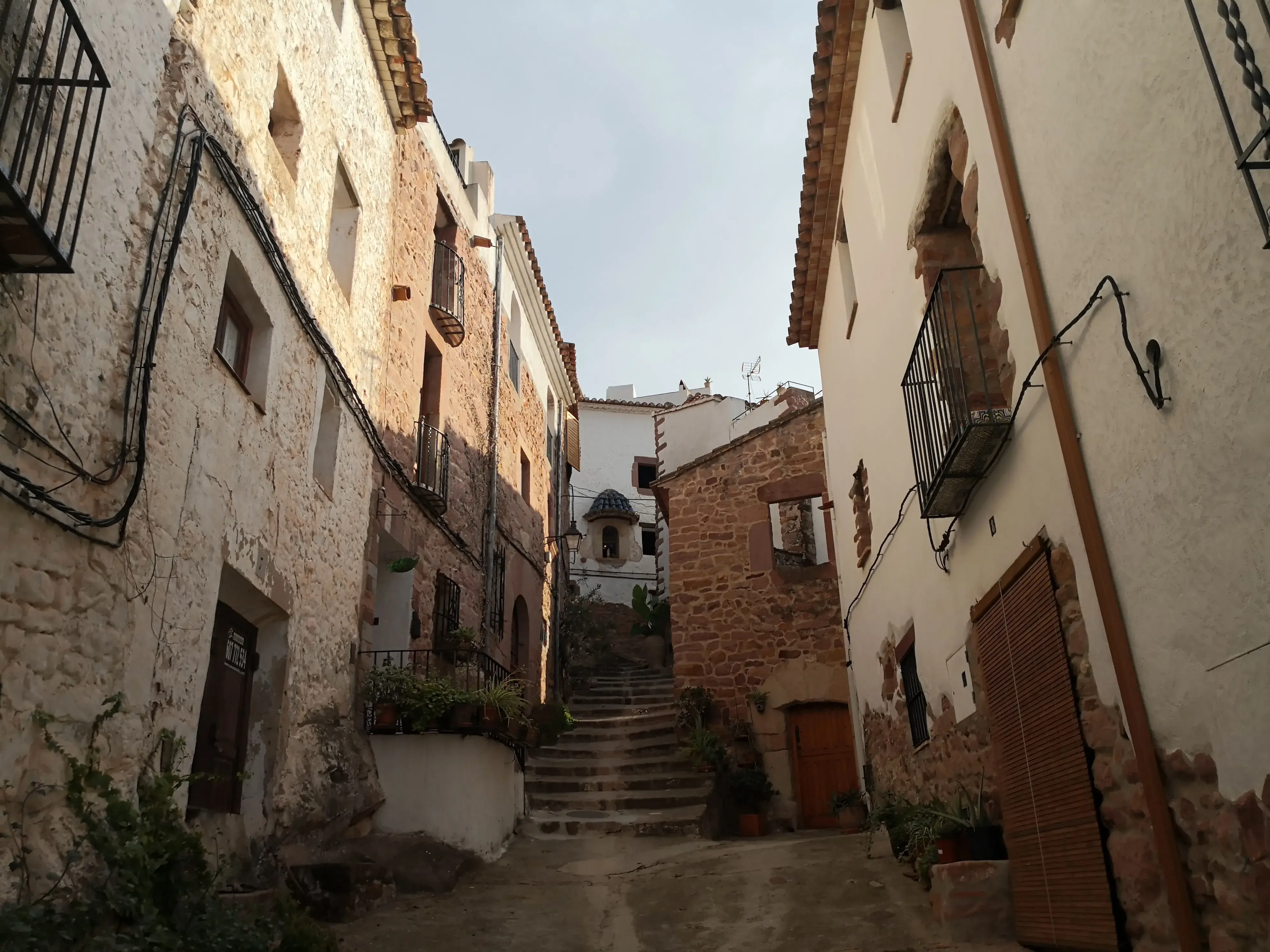 Calles de piedra roja subiendo hacia el castillo
