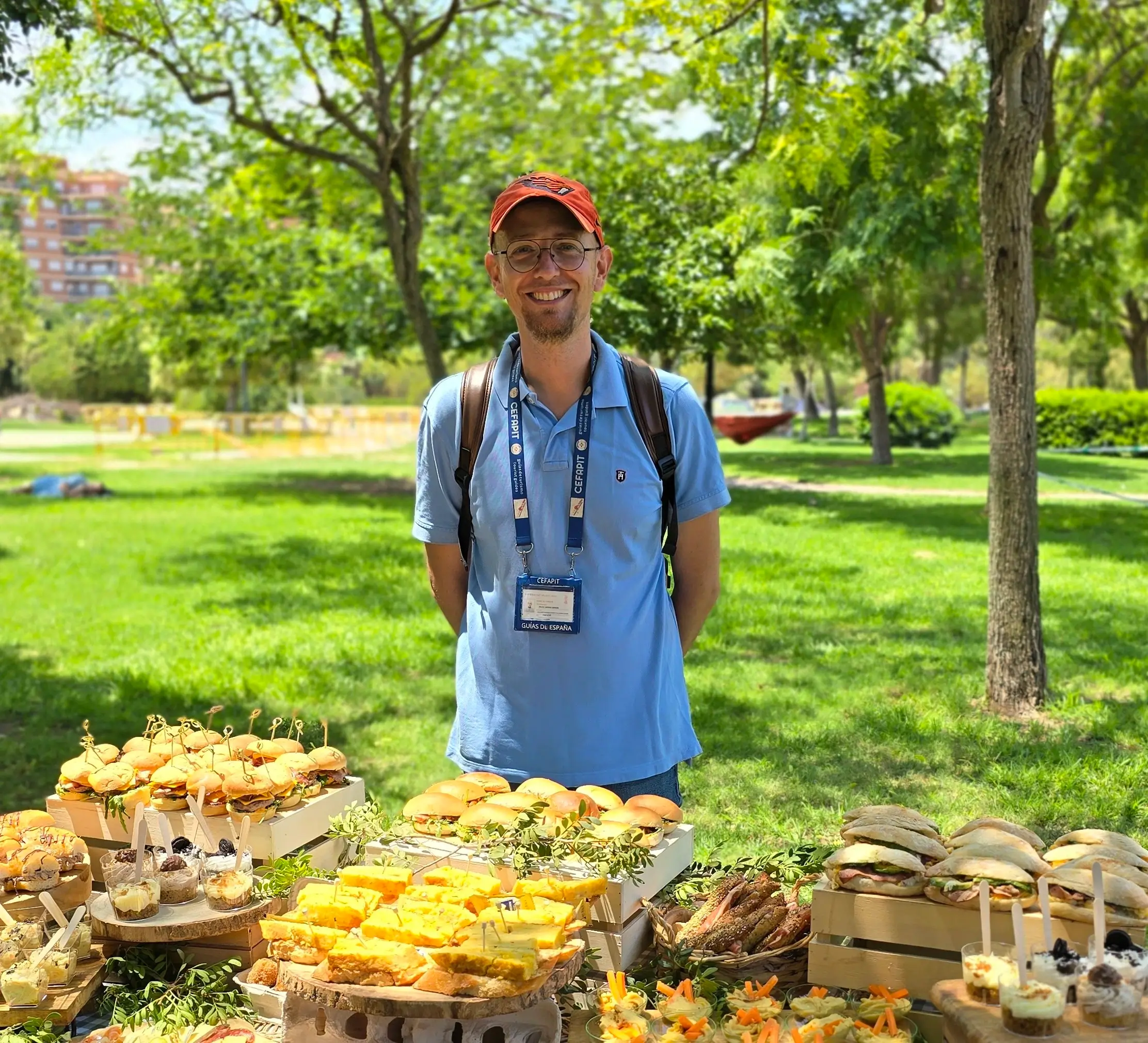 Jaume Brines sonriendo en un parque de Valencia, con su acreditación de guía oficial