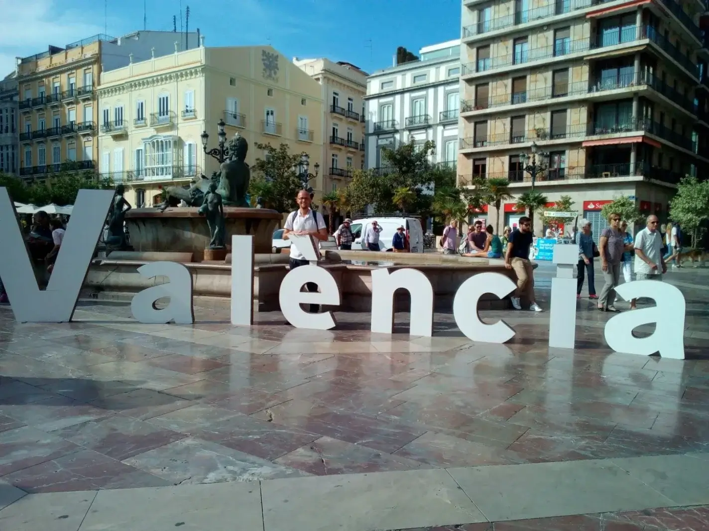 Viajeros junto a la fuente del cartel de València en el centro de la ciudad